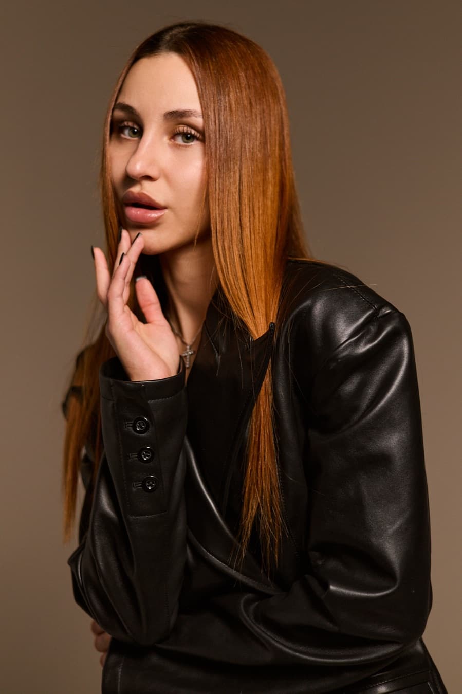 Close studio portrait, leather jacket and long straight hair