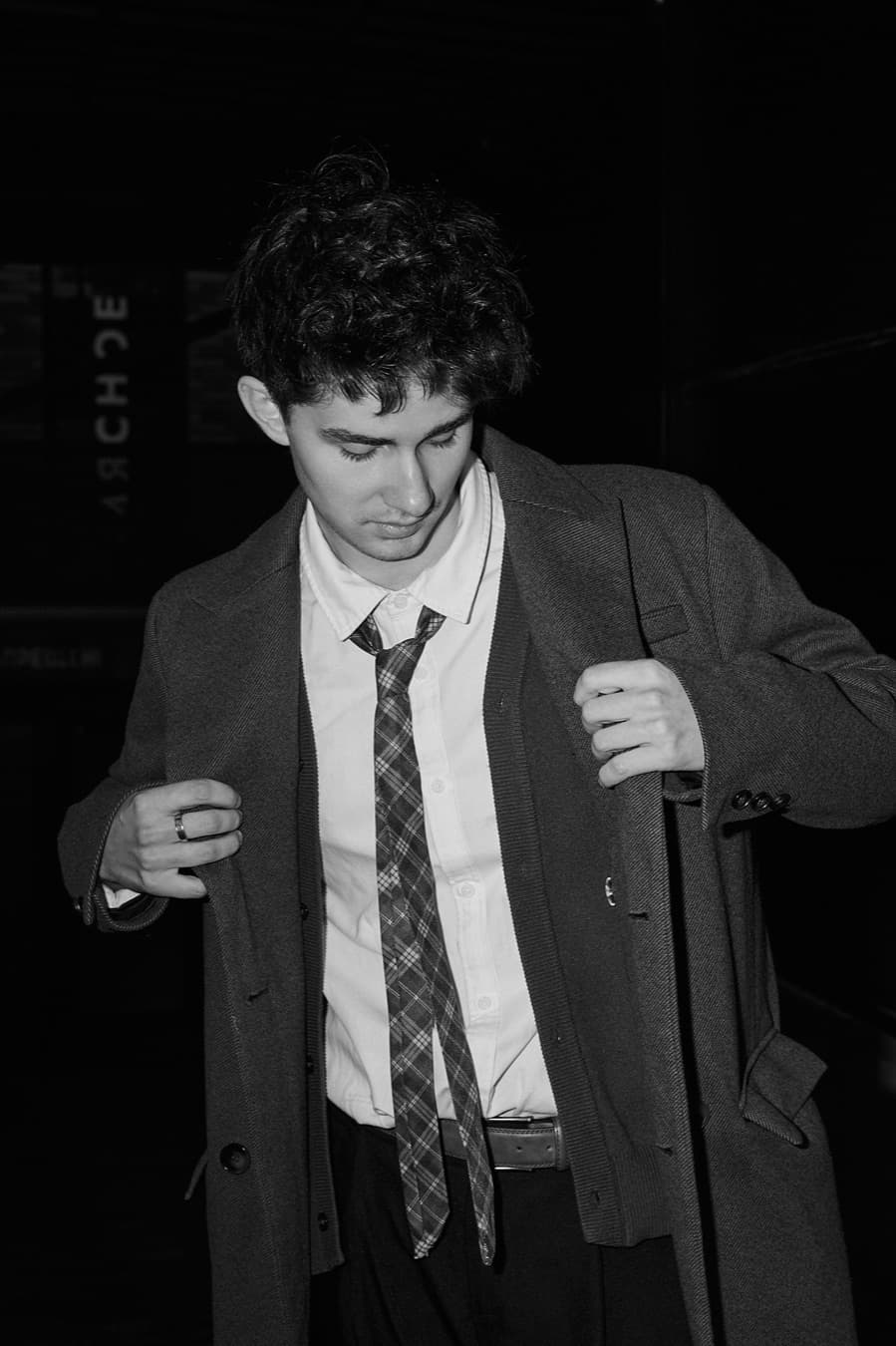 Black and white street portrait, overcoat and loosened tie