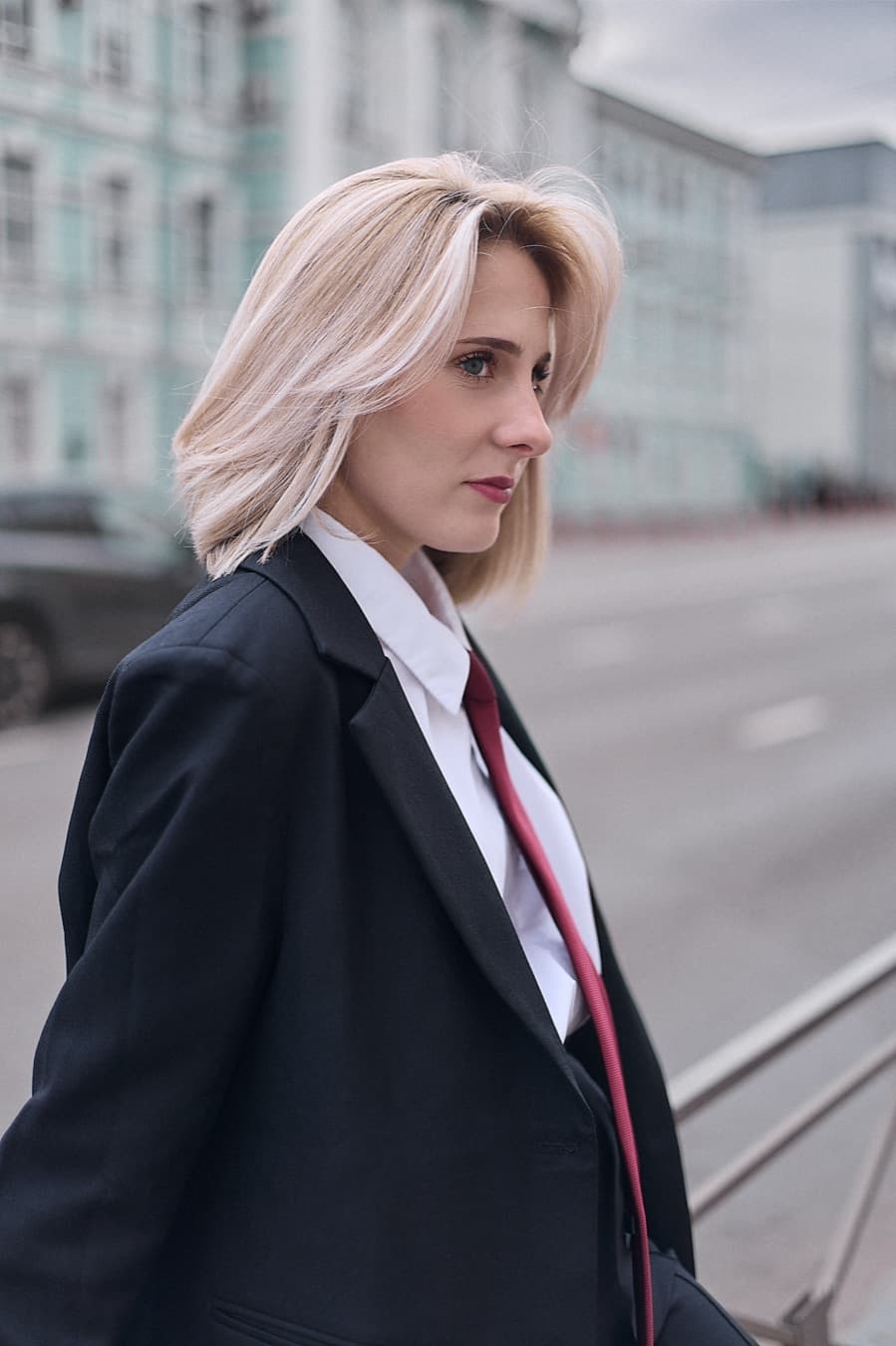 Street portrait in profile, black blazer and red tie